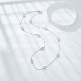 Top-down flat lay of necklace and bracelet together with moissanite sparkle