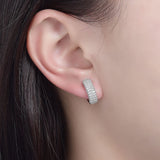 Lifestyle image: earrings worn with a tailored blazer and silk scarf