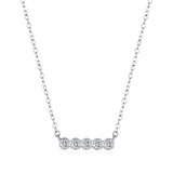 Lifestyle shot: necklace layered with a fine gold chain on neutral top