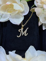 M letter pendant shown with measuring tape indicating approximate 1.2 cm diameter