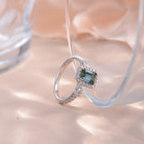 Top-down detail of geometric oval-emerald cut stone and polished band