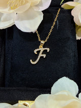 F letter pendant viewed from above to show circular shape and symmetry