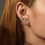 Flat lay of three heart stud earring sizes arranged by carat weight