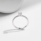 Sterling silver moissanite ring styled on a hand against neutral linen backdrop