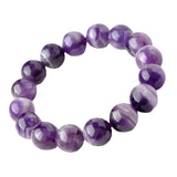 Top-down flat lay of amethyst bracelet with soft fabric backdrop and minimalist packaging