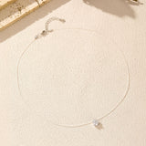 Necklace laid flat to highlight fine cable chain links and adjustable loop details