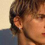 Lifestyle image: Horus Eye earrings worn on earlobe with minimalist neckline