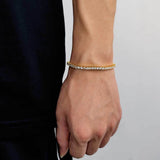 18K gold plated iced out tennis chain bracelet worn on female wrist with black top, cubic zirconia tennis bracelet for women, hip hop bling everyday jewelry gift