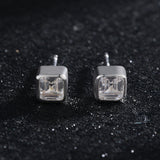 Gold-plated square stud earrings displayed on velvet surface