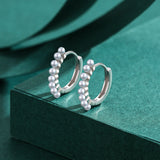 Top-down view highlighting symmetrical round shape and clean lines of hoop earrings