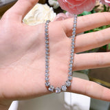 Side profile showing delicate chain links and lobster clasp of white gold necklace