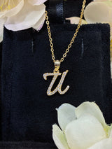 U letter pendant shown in lifestyle shot with hands clasped at chest level