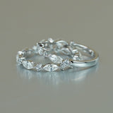 Lifestyle image of ring worn on hand against neutral textured backdrop