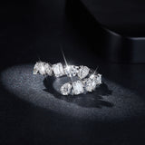 Side angle showing geometric band profile and pear-shaped center stone detail