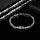 Three white gold plated cubic zirconia tennis chain bracelets stacked beside single round bracelet on black leather, iced out hip hop bling stack set for men and women