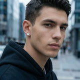 Young man in streetwear wearing small stainless steel magnetic CZ stud — urban portrait
