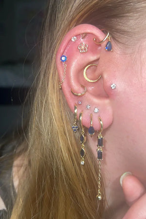 Close-up of an ear with Fitiny stacked gold and cz earrings.
