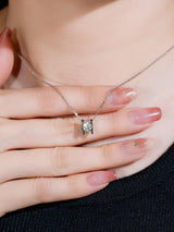 Lifestyle shot: necklace styled with white turtleneck and gold watch