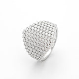 Top-down lifestyle shot of ring placed on textured charcoal fabric with subtle shadow and natural light