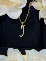 J letter pendant against soft gradient background highlighting metallic sheen