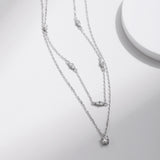 Side-angle detail showing layered chain structure and square moissanite-accented pendant