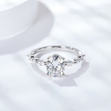 Front view of elegant oval moissanite ring with four-prong setting on white background