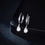 White gold version of teardrop earrings displayed on velvet jewelry tray