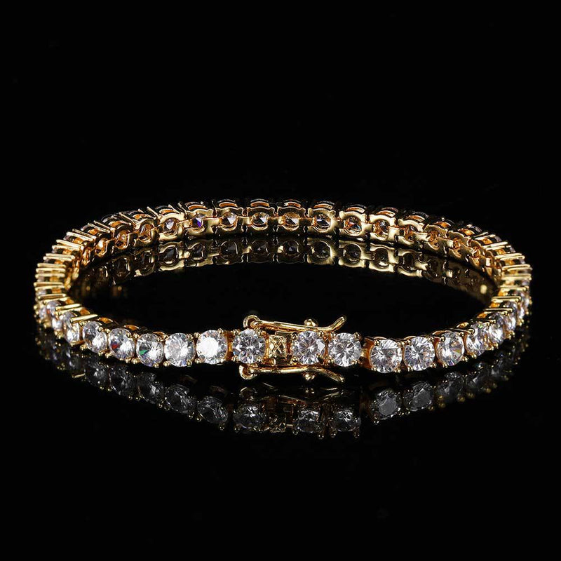 18K gold plated iced out tennis chain bracelet shown in a round hero shot on black reflective surface, single row of round cut cubic zirconia stones, hip hop bling jewelry for men and women