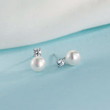 Pearl and moissanite earrings beside botanical elements for French aesthetic