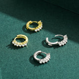 Gold-plated version of crystal hoop earrings on neutral backdrop