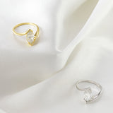 White gold version of oval moissanite ring displayed on velvet ring holder