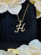 H letter pendant on model's collarbone showing proportional fit and drape