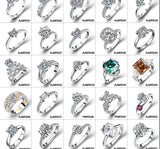 Rings displayed on rustic wooden table with eucalyptus sprig