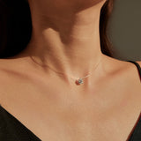 Close-up of round moissanite center stone with brilliant sparkle and sterling silver prong setting