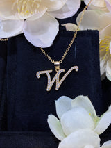W letter pendant with bokeh background highlighting minimalist typography