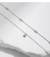 Flat-lay composition featuring necklace beside FITINY branded gift box and satin ribbon