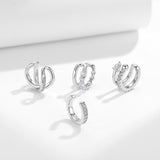 Lifestyle image of ear cuff worn on upper ear cartilage against neutral backdrop