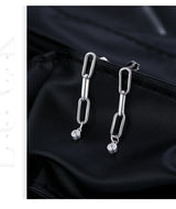 Lifestyle flat lay with earrings beside notebook and coffee cup