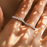 Lifestyle shot of hand wearing stacked rings including this geometric moissanite piece