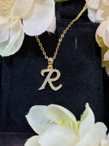 R letter pendant under studio lighting showing contrast between white gold and gold finishes