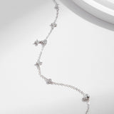 Side profile showing delicate chain and clover detail of silver bracelet