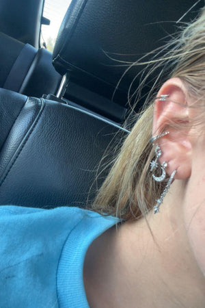 A girl wearing 6 Pairs Chic Star and Moon Stacked Earring Sets