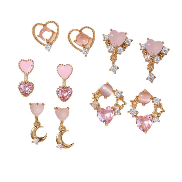 Set of pink gemstone earrings with gold and crystal accents on a white background