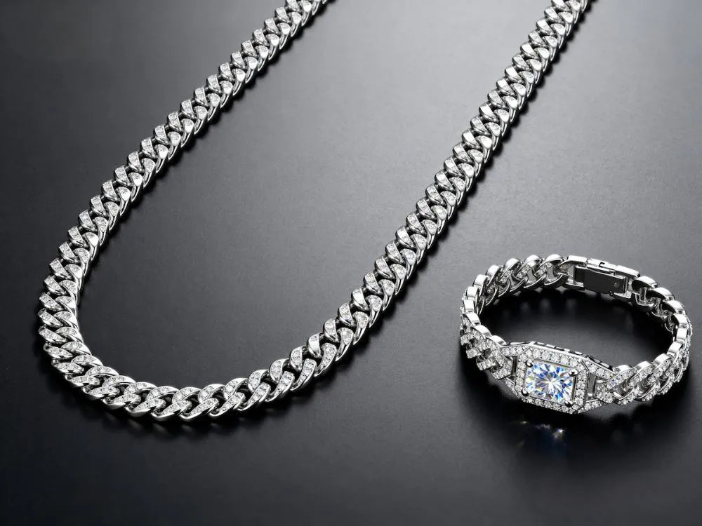 Iced moissanite tennis necklace, tennis bracelet and Cuban chain on a dark gradient background.
