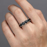 Black moissanite stack ring worn on a man's ring finger — close-up