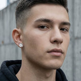 Small 8mm stainless steel magnetic CZ stud worn flat on a young man's earlobe — sharp close-up
